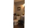 Cozy half bathroom with a pedestal sink, toilet, and stylish decor at 301 Orange Blossom Dr, Winter Haven, FL 33880