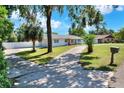 Well-maintained single-story home with a long driveway, green lawn, and mature trees at 3522 Royal S Ct, Lakeland, FL 33812