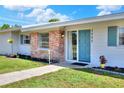 Inviting front entrance with a light blue door, brick accents, and beautifully landscaped surroundings at 3522 Royal S Ct, Lakeland, FL 33812