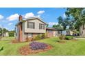 Spacious home with a brick chimney and a well-maintained lawn with garden beds at 4908 Celia W Cir, Lakeland, FL 33813