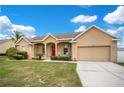 Charming single Gathering home with a well-manicured lawn and inviting front porch with a bright red door at 5370 Knights Station Rd, Lakeland, FL 33810