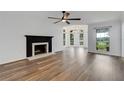 Spacious living room with a fireplace, fan, wood-look floors, and large windows at 5722 Antler Trl, Lakeland, FL 33811