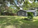 Backyard view of renovated home with gray paint, white trim, privacy fence, and well-maintained yard at 6127 Crews Lake Rd, Lakeland, FL 33812
