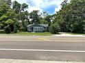 Street view of renovated home with attractive gray paint, white trim, and verdant trees surrounding the property at 6127 Crews Lake Rd, Lakeland, FL 33812