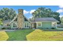Inviting one-story home featuring a stone chimney and well-manicured lawn at 6533 Angus Dr, Lakeland, FL 33810