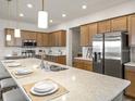 Modern kitchen with stainless steel appliances, island with seating, and pendant lighting at 7515 Sw 107Th Ln, Ocala, FL 34476