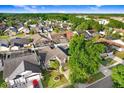 Aerial view of a neighborhood showcasing neatly arranged homes surrounded by lush green trees at 8818 Tottenham Way, Kissimmee, FL 34747