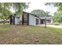 Charming home featuring stone accents, dark grey garage door, and a well-maintained front yard at 910 Van Dr, Auburndale, FL 33823
