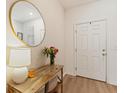 Warm foyer featuring stylish mirror, rustic console table, and flowers at 943 Grandin St, Davenport, FL 33837