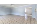 Spacious living room featuring tiled floors, fresh paint, and ceiling fan at 121 F Sw Ave, Winter Haven, FL 33880