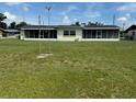 Expansive backyard featuring a full lawn and a screened-in lanai spanning the home's rear at 1216 W Lake Buckeye Dr, Winter Haven, FL 33881
