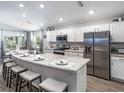 Modern kitchen featuring a large island with seating, stainless steel appliances, and ample counter space at 1509 Otter Woods Ln, Auburndale, FL 33823