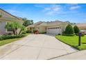 Well-maintained home with a long concrete driveway, two-car garage, and neatly landscaped front yard at 1707 Laurel Glen Pl, Lakeland, FL 33803