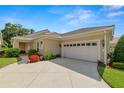 Beautiful home featuring a tile roof, attached two-car garage, and colorful floral accents at 1707 Laurel Glen Pl, Lakeland, FL 33803