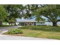 Charming home exterior featuring a large front lawn, a vibrant blue front door and a lake view at 21 Lake Ave, Winter Haven, FL 33880