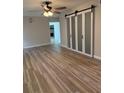 Bright room showcasing barn doors, laminate flooring, and a view into another room at 21 Lake Ave, Winter Haven, FL 33880