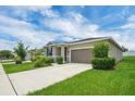 Beautiful single-story home features a well-manicured lawn, mature shrubbery and an attached garage at 221 Hilltop Bloom Loop, Haines City, FL 33844