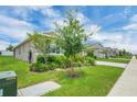 Beautifully landscaped front yard with lush green grass and a variety of shrubs and plants at 221 Hilltop Bloom Loop, Haines City, FL 33844