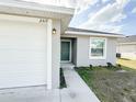 Inviting single-story home with an attached garage, manicured lawn, and a modern green front door at 2517 Sunset Dr, Winter Haven, FL 33881