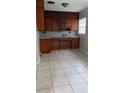 Functional kitchen with tile flooring, classic cabinetry, and tiled backsplash at 2708 Dixie Rd, Lakeland, FL 33801
