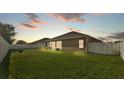 Large grassy backyard with a white fence and a neighboring house in the background at 2812 Whitney St, Lakeland, FL 33813