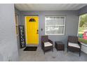 Inviting front porch with seating and a vibrant yellow door, creating a warm welcome at 3015 Thornhill Rd, Winter Haven, FL 33880