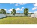 Spacious backyard with lush green grass, black metal fence, and picturesque lake views, perfect for outdoor enjoyment at 3739 Peregrine Way, Lakeland, FL 33811