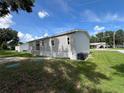 Well-maintained home exterior with vinyl siding, lush green lawn, and mature trees at 3780 Pioneer Trails St, Lakeland, FL 33810