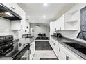 Modern kitchen with white cabinets, black hardware, a black countertop, and stainless steel appliances at 3854 Feather Dr, Lakeland, FL 33812