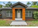 Up close front porch view showcasing wood support beams and white door at 504 Prado Pl, Lakeland, FL 33803