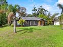 Single-story home boasts a large front yard, mature landscaping, and freshly painted facade at 504 Prado Pl, Lakeland, FL 33803