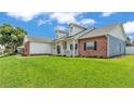 Side view of the home showing the manicured lawn, brick accents, and inviting front porch at 5579 Summerland Hills Dr, Lakeland, FL 33812