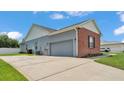 The side of the house featuring a spacious driveway leading to an attached two-car garage at 5579 Summerland Hills Dr, Lakeland, FL 33812