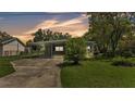 Cozy single-story home with a covered carport and well-maintained lawn at dusk at 640 Forrest Dr, Bartow, FL 33830