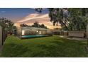 A backyard showcasing a large, screened-in pool area with ample green space surrounding it at 6406 Butternut Dr, Lakeland, FL 33813
