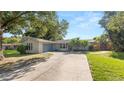Charming single-story home with a well-maintained lawn and a driveway at 6421 Calusa Dr, Lakeland, FL 33813
