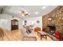 Spacious living room with a stone fireplace, tile floors, and a ceiling fan at 6421 Calusa Dr, Lakeland, FL 33813