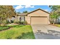Inviting home exterior with a two-car garage, complemented by a green lawn and garden beds at 6964 Lake Eaglebrooke Dr, Lakeland, FL 33813