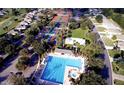 Aerial view of community pool, tennis courts, and meticulously landscaped grounds at 9017 Se 119 St, Summerfield, FL 34491