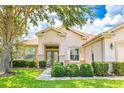Inviting home exterior with lush landscaping, manicured shrubs, and a charming front entrance at 9017 Se 119 St, Summerfield, FL 34491