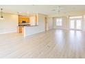 Bright, open-concept living space featuring wood-look floors connecting the living area to the kitchen at 9017 Se 119 St, Summerfield, FL 34491