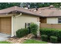 Cozy home exterior with a one-car garage, brick walkway, and neatly trimmed bushes at 925 Fenton Ln # 18, Lakeland, FL 33809