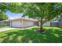 Charming single-story home with a well-manicured lawn, mature tree, and an attached two-car garage at 1081 Sunshine Sw Way, Winter Haven, FL 33880