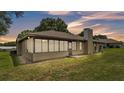View of the back exterior with Florida room and spacious green lawn at 113 W Juliana Way, Auburndale, FL 33823