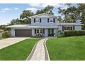 Charming two-story home with beautiful landscaping and a walkway to the front door at 1210 Heidi S Ln, Lakeland, FL 33813