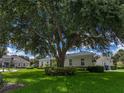 A cozy one-story home with well-manicured lawn and mature trees providing ample shade at 128 Melissa Trl, Auburndale, FL 33823