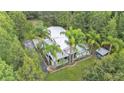 Stunning aerial view showcasing the home's setting with lush landscaping and mature trees at 15345 Angus Rd, Polk City, FL 33868