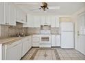 Well-lit kitchen with white cabinets and appliances, complemented by tile flooring at 1610 Reynolds Rd # 214, Lakeland, FL 33801