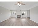 Cozy living room with fireplace, ceiling fan, neutral color palette, and wood-look floors at 2055 S Floral Ave # 245, Bartow, FL 33830