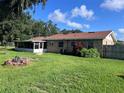 Backyard featuring a screened porch, fire pit area and wood fence at 2105 E Cherokee St, Bartow, FL 33830
